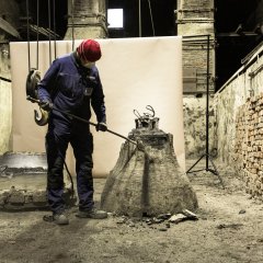 Die Glocke wird aus dem Boden geholt und von Tonresten befreit.